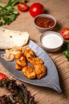 top view of a chicken kebab in a plate on a table in a restaurant.