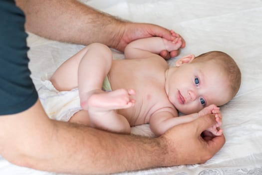 Father's focused approach to massaging his infant highlights the depth of paternal love and care