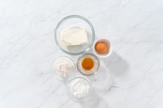 Flat lay. Measured ingredients in glass mixing bowls to make the cream cheese filling.