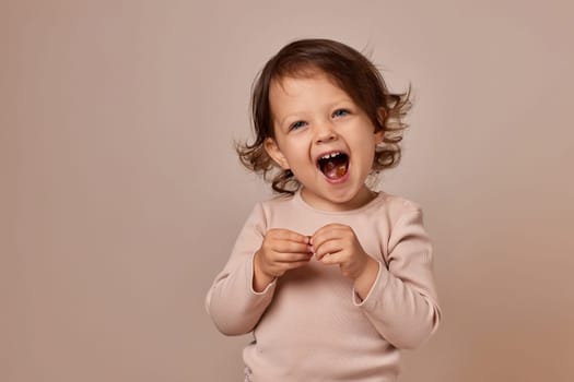 smiling child girl holding fruit pastille on beige background. healthy baby food.