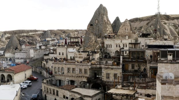 Ancient stone dwellings carved from tuff in Cappadocia, Turkey, aerial. Action. Aerial view of beautiful city with rock formations