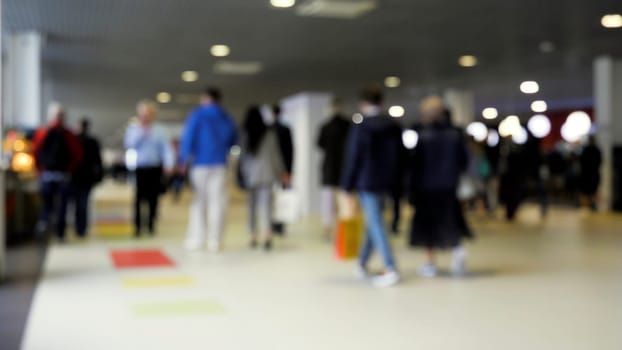 Exhibition hall. Media.A huge stream of people walking with bags filmed without focus. High quality 4k footage