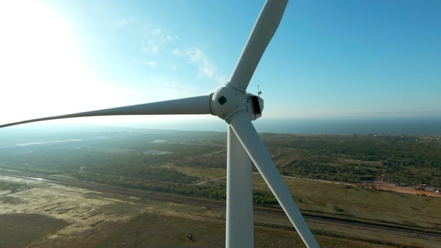 Top view of windmill on horizon background. Shot. Beautiful landscape with windmill at dawn. Modern wind turbine on background of summer landscape.