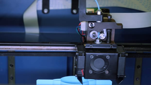 Close-up of moving machine in 3d printer. Media. Creating objects on 3D printer with machine. Process of operation of 3d printer machine during printing.