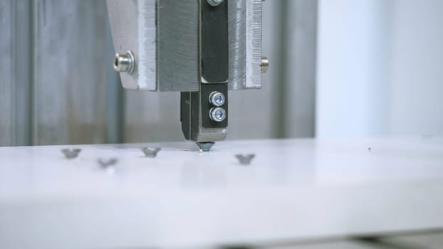 Machine twisting nails. Media. Close-up of automated machine twisting nails. Production machine that screws nails and bolts on boards.
