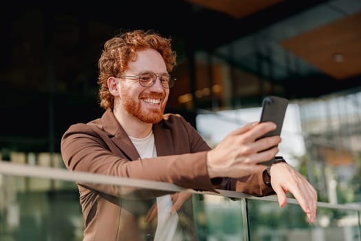 A vibrant man interacts enthusiastically with his smartphone, showcasing a modern lifestyle and technology