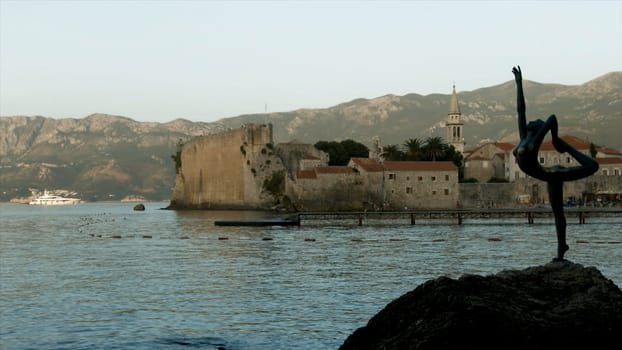 Montenegro, Budva - June 1, 2022: Beautiful view of coast with old stone town on background of mountains. Creative. Beautiful ancient city on seashore in Europe. Historic city with beautiful ancient architecture.