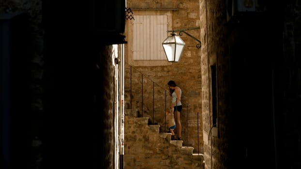 Mother and her boy child walking near antique stone building. Creative. Old beautiful fortress and family travelling near
