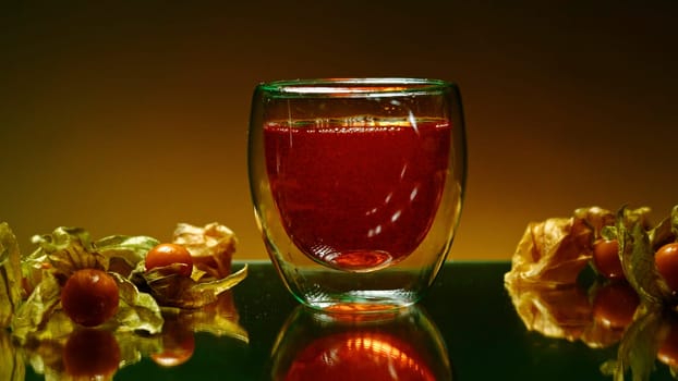 Still life with cognac. Stock clip.Orange background with a view of an alcoholic carbonated drink and small tangerines lying nearby. High quality 4k footage