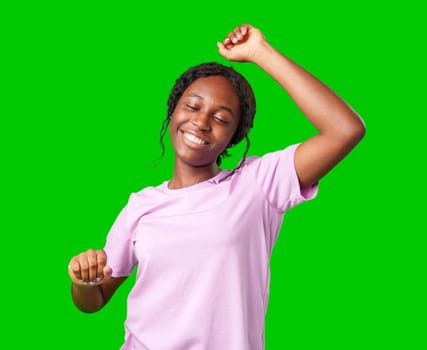 A young woman with braids expresses excitement with a clenched fist against a bright green background in studio