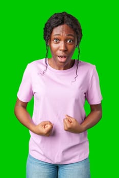 Woman expressing surprise and excitement on a bright green background in studio