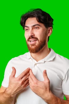Smiling man in a white polo shirt standing confidently against a bright green background close up