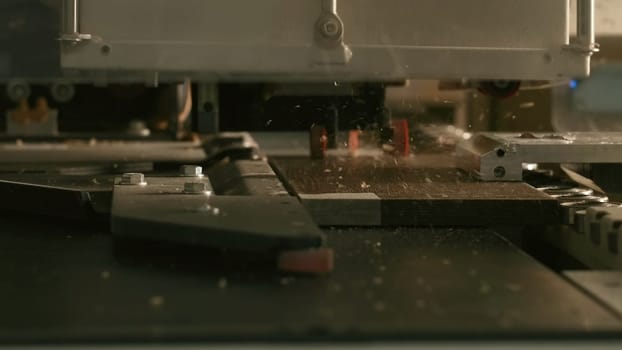 Close-up of automated drilling machine on wood. Creative. Automated machine for production of wood products processing. Drilling machine for holes in wooden boards.