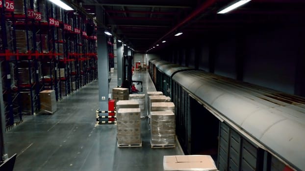 Unloading of freight trains. Creative. Parked wagons with goods in the warehouse for unloading and folding boxes. High quality 4k footage
