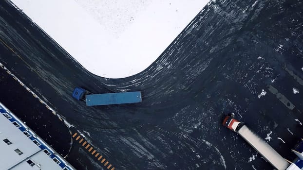 View from a helicopter. Creative. Long bright-colored trucks that move next to industrial plants turning in different directions. High quality 4k footage