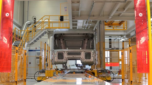 Metal frame of car at factory. Scene. Body frame for truck is assembled at factory. Car and frame assembly at modern factory.