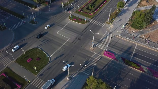 Top view of city intersection on summer day. Clip. Beautiful road intersection with morning traffic in sunny weather. Summer city crossroads on sunny day.