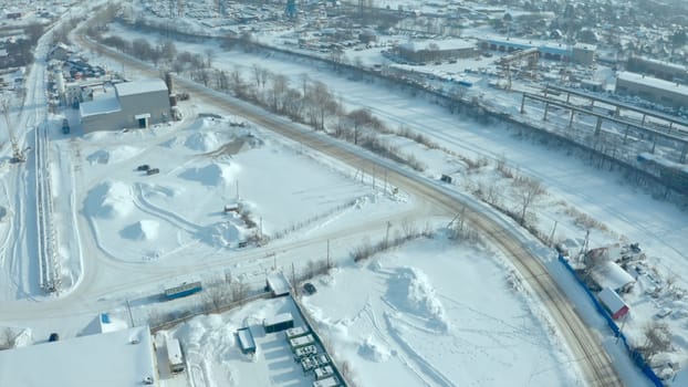 Top view of industrial area in winter. Clip. Industrial area in countryside on winter day. Small businesses outside city in winter.