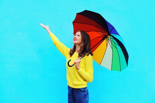 Happy pretty smiling young woman with colorful umbrella in autumn day