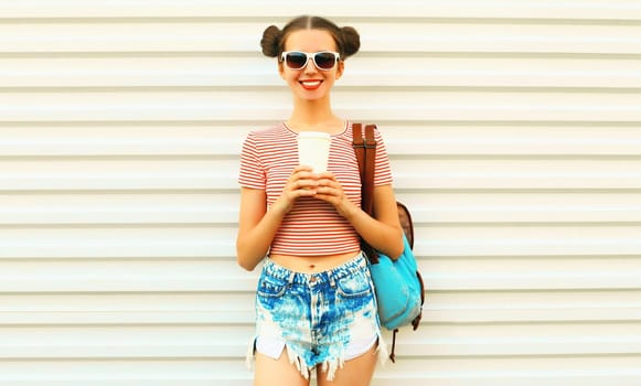 Portrait of happy smiling young woman drinking coffee with cool hairstyle on white background