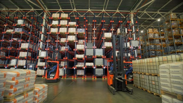 Russia Moscow - February 24, 2022: Worker on transport ride in large warehouse. Creative. Loader on transport works in warehouse of enterprise or store. Working in warehouse.