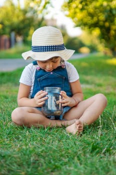 A child looks through a magnifying glass in nature. Selective focus. kid,