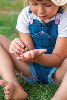 A child looks through a magnifying glass in nature. Selective focus. kid,
