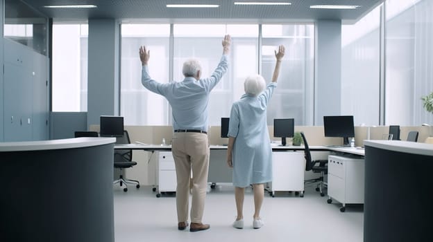 A man and a woman are both standing excitedly in an office, with their arms raised high in the air, celebrating a significant achievement or moment