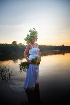Girl in White Sundress With Flower Wreath in Water at Sunset Celebrating Ivan Kupala Holiday