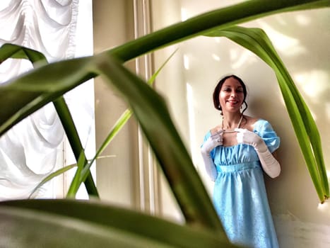 A young lady dressed as a princess stands elegantly in an ancient castle, embodying a vintage romantic aesthetic.