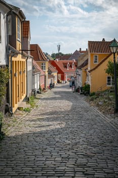 ebeltoft,denmark,30-08-2024:Quaint European street featuring vibrant buildings and cobblestone path under a blue sky. A serene atmosphere, perfect for exploringebeltoft