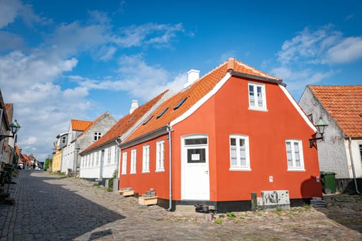 ebeltoft,denmark,30-08-2024:Quaint European street featuring vibrant buildings and cobblestone path under a blue sky. A serene atmosphere, perfect for exploringebeltoft