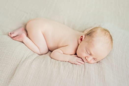 The baby is sleeping peacefully in his cozy nest. Newborn photo session captures the serene innocence and warmth of early moments.