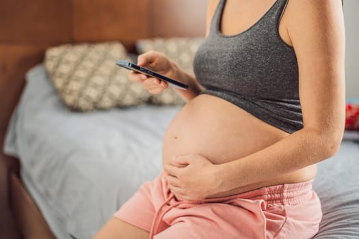 Mobile pregnancy online maternity application. Pregnant mother using phone. Pregnancy, medicine, pharmaceutics, health care and people concept.