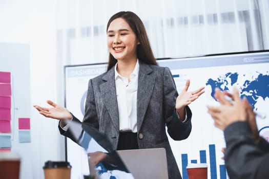 Young asian businesswoman presenting data analysis dashboard on TV screen in modern meeting. Business presentation with group of business people in conference room. Concord