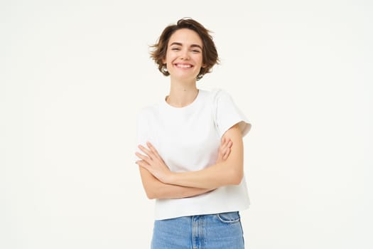 Portrait of cheerful woman laughing and smiling, cross arms on chest, standing in confident power pose, young professional concept, white studio background.