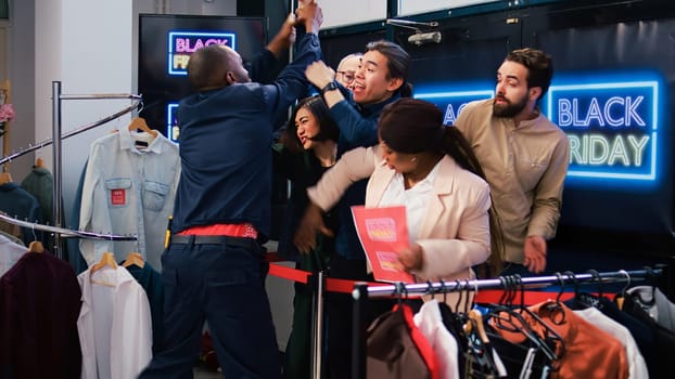 Black friday clients tired of waiting, angry obsessed shoppers eager to start shopping. Customers arguing with security employee, demanding to open store during seasonal sales.