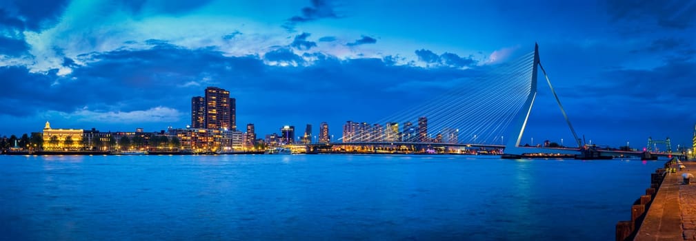 Panorama of Erasmus Bridge (Erasmusbrug) and Rotterdam skyline illuminated at night. Rotterdam, Netherlands