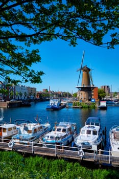 View of the harbour of Delfshaven with the old grain mill known as De Destilleerketel. Rotterdam, Netherlands