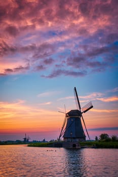 Netherlands rural landscape with windmills at famous tourist site Kinderdijk in Holland on sunset with dramatic sky