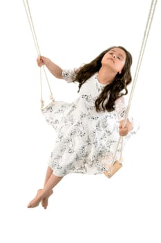 From above cute long haired girl in light dress riding high on swings