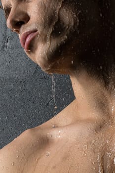 Shirtless muscular man wearing only jeans cropped view in shower