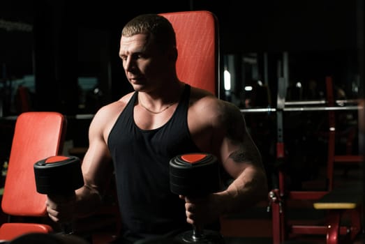 Athletic man exercising on a simulator view in sports gym