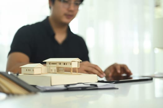Close up a detailed scale model of a house on architect workspace.