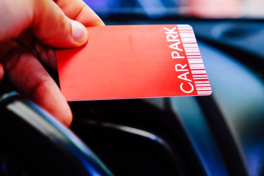 Driver is holding parking card getting ready to exit parking