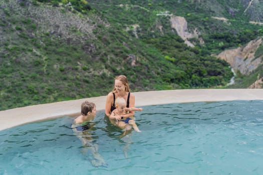 Mother with her toddler and teenage sons bathing in the hot springs of Grutas Tolantongo, Mexico. Family adventure, relaxation, and natural wellness concept.