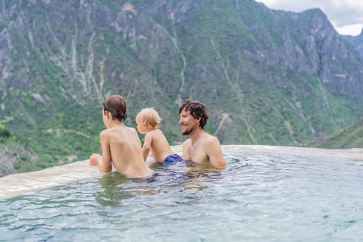 Father with his toddler and teenage sons bathing in the hot springs of Grutas Tolantongo, Mexico. Family adventure, relaxation, and natural wellness concept.