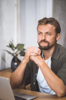 A man sitting in front of a laptop computer.