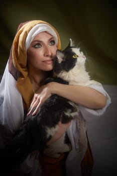 A girl in vibrant national attire cradles a cat while portraying Rebekah, conveying warmth and connection during the shoot.
