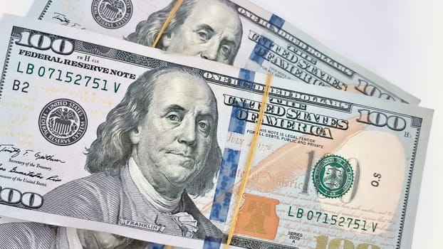 A Fan of $100 Bills.A close-up photo of a fan of $100 US dollar bills. The bills are arranged neatly, with the portrait of Benjamin Franklin visible on each bill. The background is white.Finance ve economy concept.